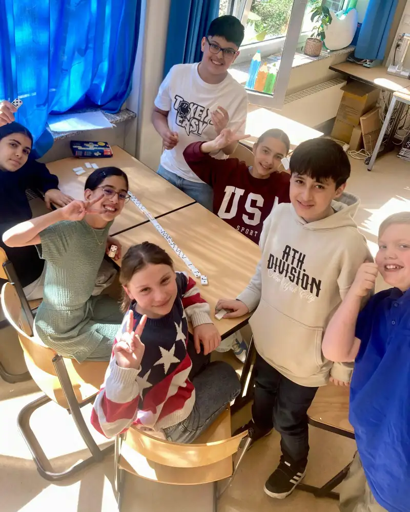 Eine fröhliche Gruppe Kinder spielt Domino