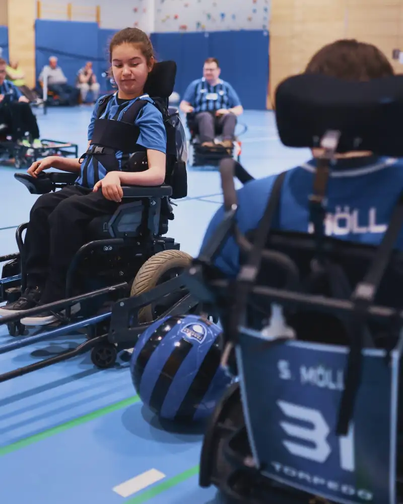 E-Rollfahrer*innen beim Fußballspiel