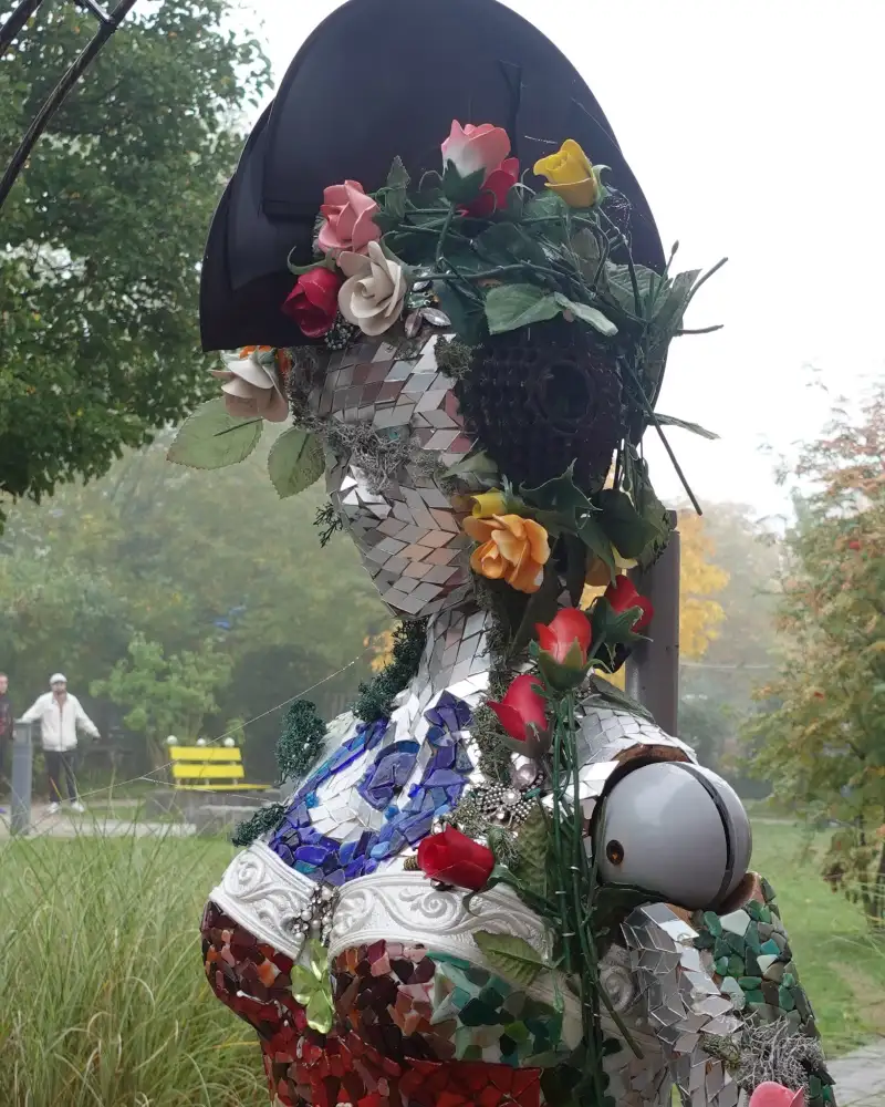 Eine mit Blumen verzierte menschliche Figur in einem Garten
