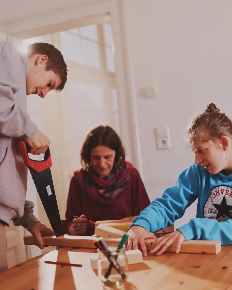 Menschen mit und ohne Behinderung an einem Tisch beim Werken