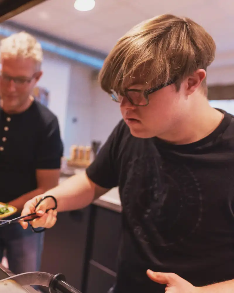 Ein Mann mit Downsyndrom arbeitet in einem Cafe