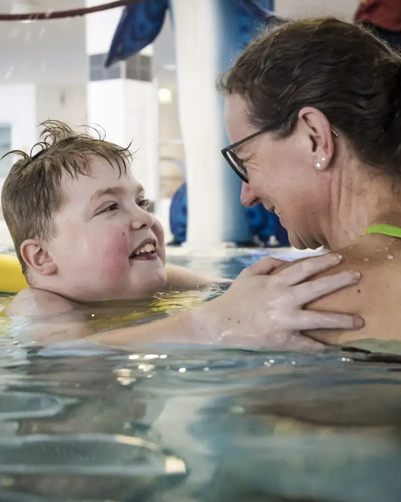 Eine Frau mit einem Kind im Schwimmbecken