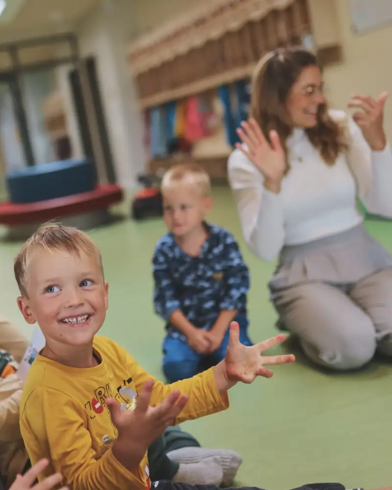 Vier Kinder und drei Erzieherinnen singen zusammen.