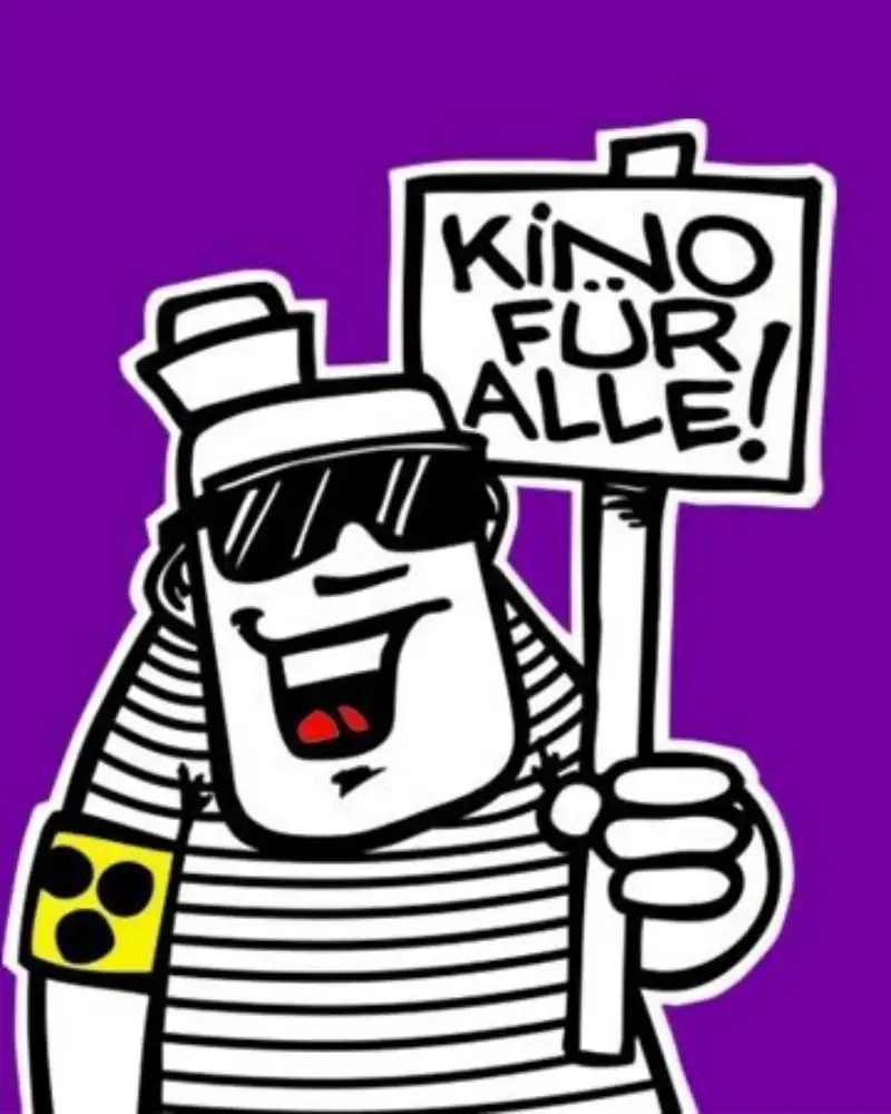 Grafik: Eine gezeichnete Person mit dunkler Brille und gelber Armbinde mit drei schwarzen Punkten halt ein Schild hoch, auf dem steht: Kino für alle. Außerdem ist eine Filmklappe zu sehen, unter der steht: Klappe auf!