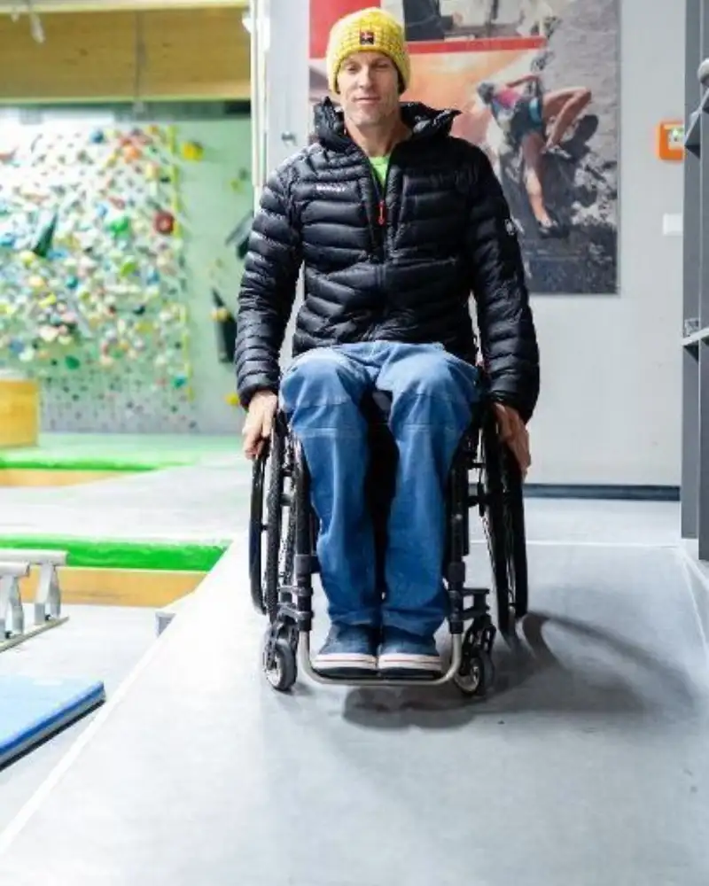 Ein Mann im Rollstuhl in einer Boulder-Halle