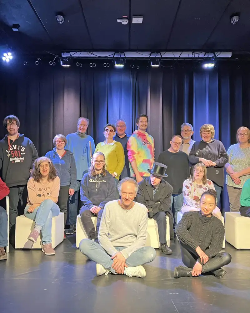 Eine Gruppe von Schauspieler*innen auf einer Bühne, auf der auch viel Plastikmüll liegt