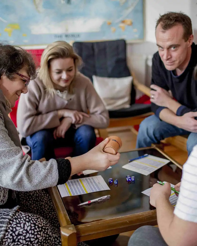 Vier Personen beim Spiel an einem Couchtisch