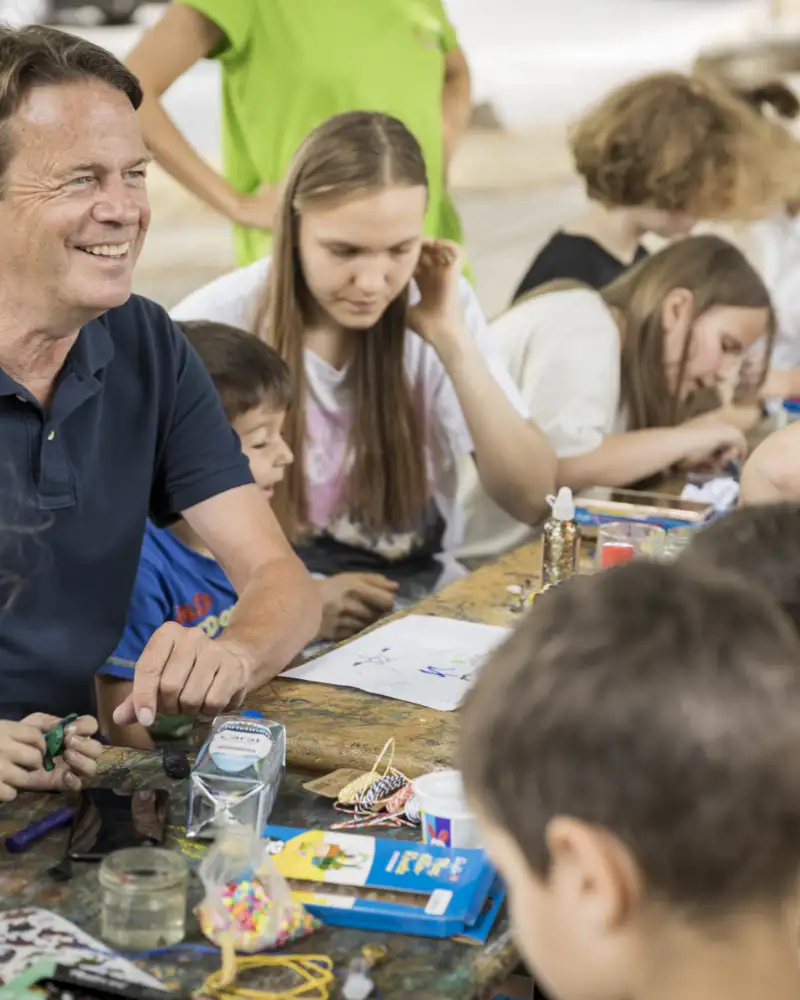 Rudi Cerne und Kinder an einem Tisch beim Basteln