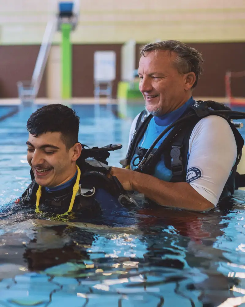 Drei Männer mit Tauchausrüstung in einem Schwimmbecken