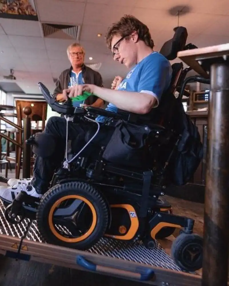 Ein junger Mann im E-Rolle auf einer Rampe in einer Kneipe