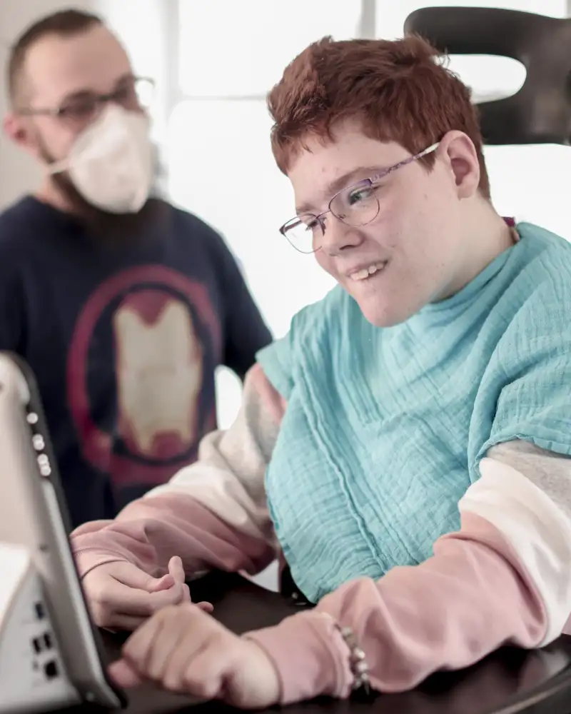 Eine Frau mit Behinderung vor einem Bildschirm