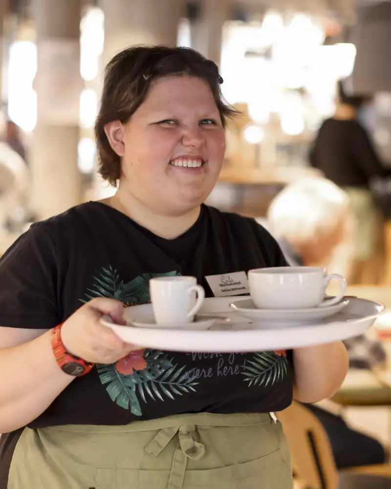 Eine junge Frau serviert in einem Café