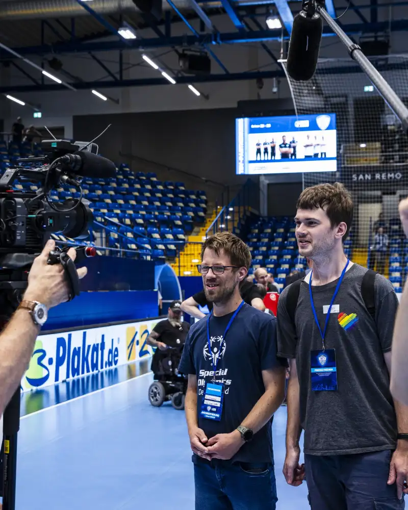Interviewszene mit Sportlern in einer Sporthalle