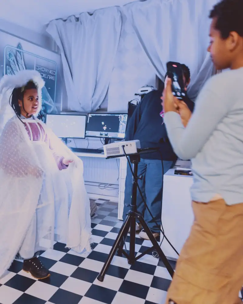 Ein Junge filmt ein Mädchen in weißer Verkleidung