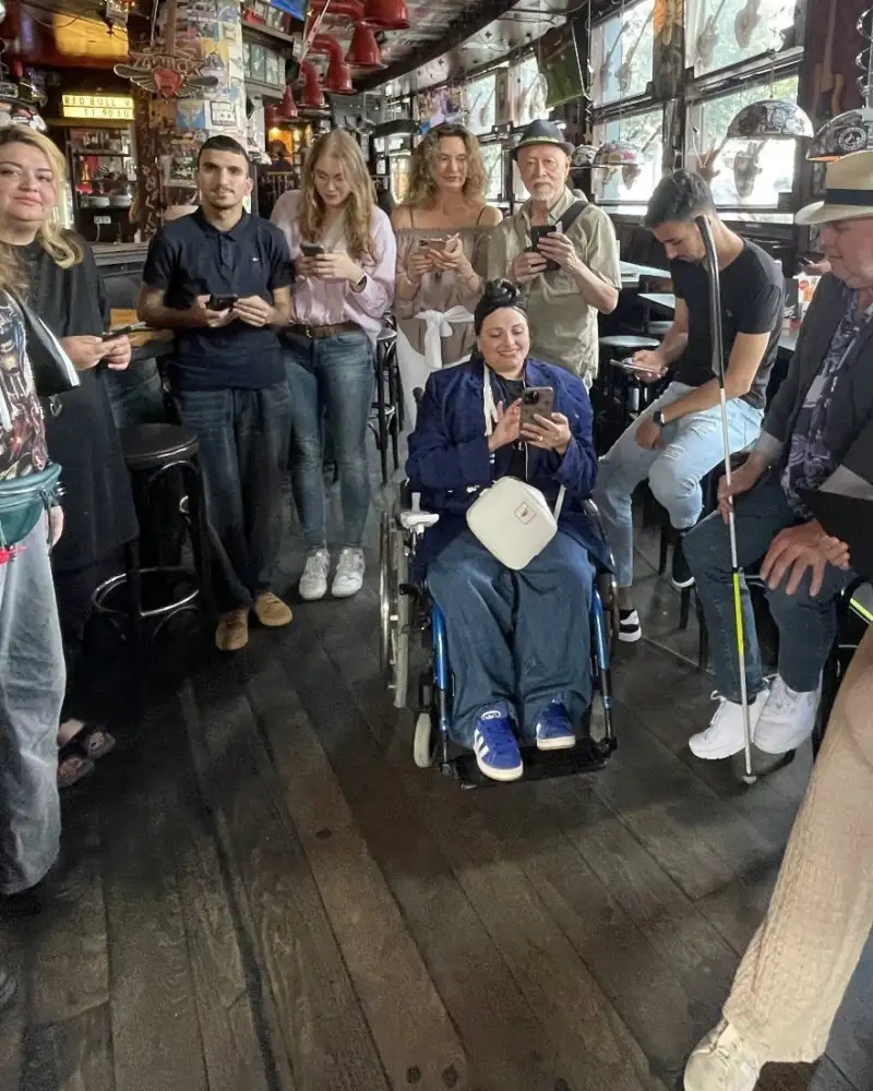 Eine größere Gruppe von Personen mit und ohne Behinderung in einem Café