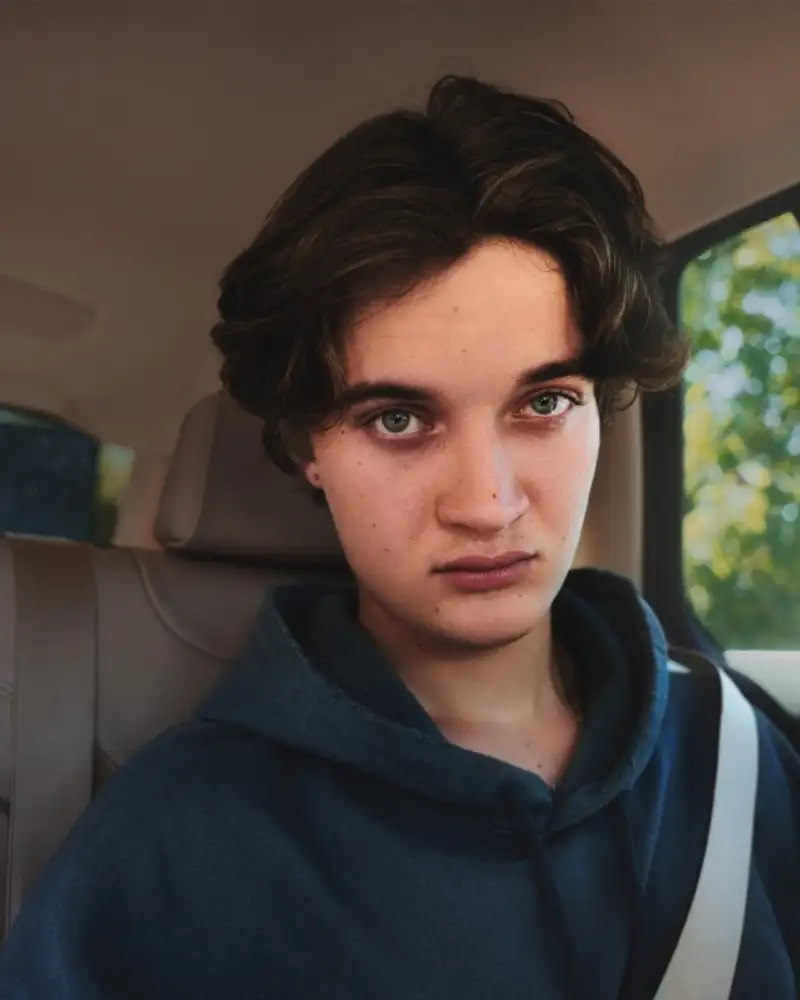 Ein Jugendlicher sitzt mit ernstem Blick im Auto.