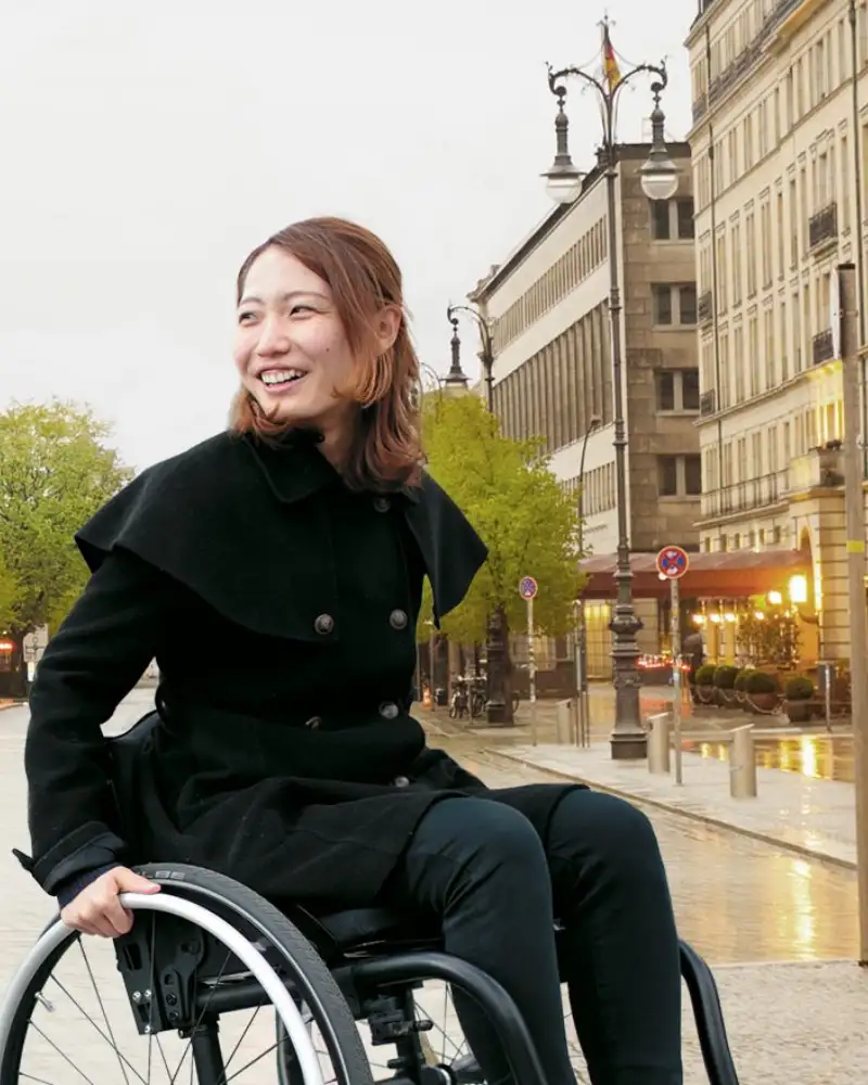Zwei junge Frauen sind in der City unterwegs. Eine von ihnen sitzt im Rollstuhl.
