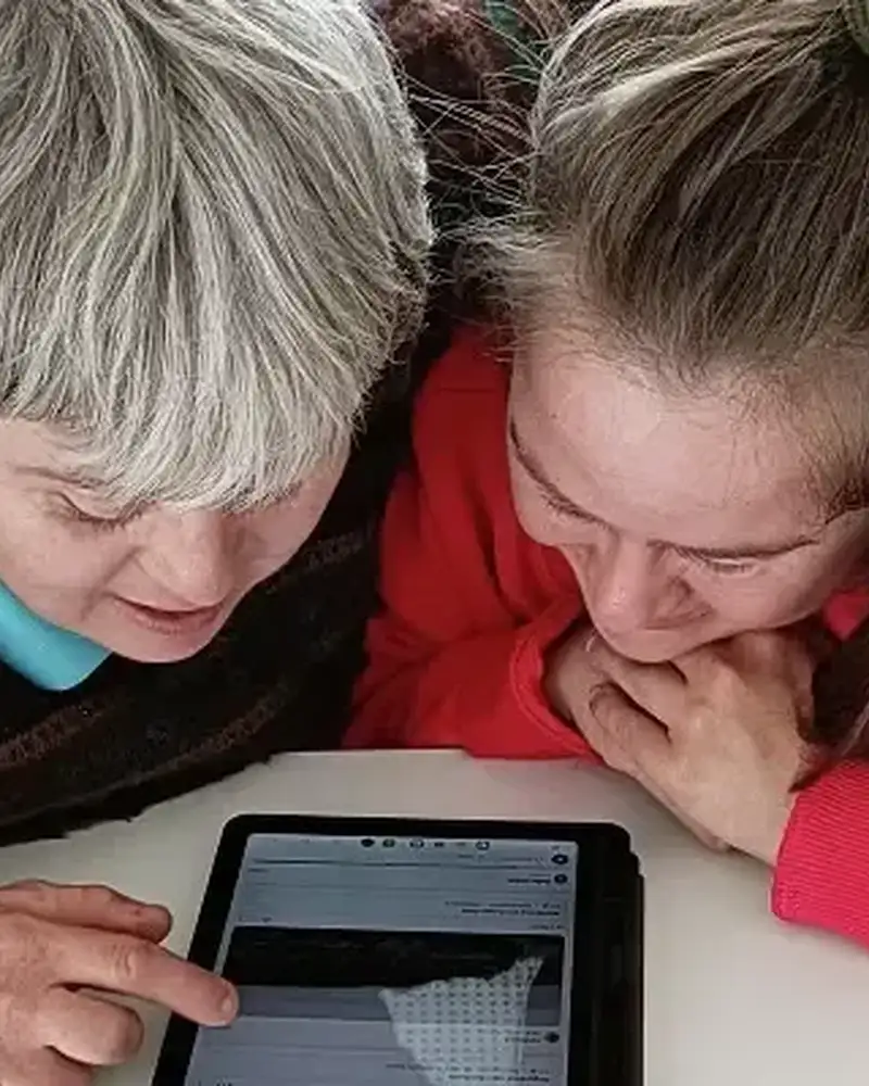 Zwei Frauen beugen sich über ein Tablet.