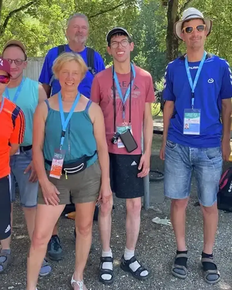 Eine Gruppe von Menschen mit und ohne Behinderung in sportlicher Sommerkleidung.