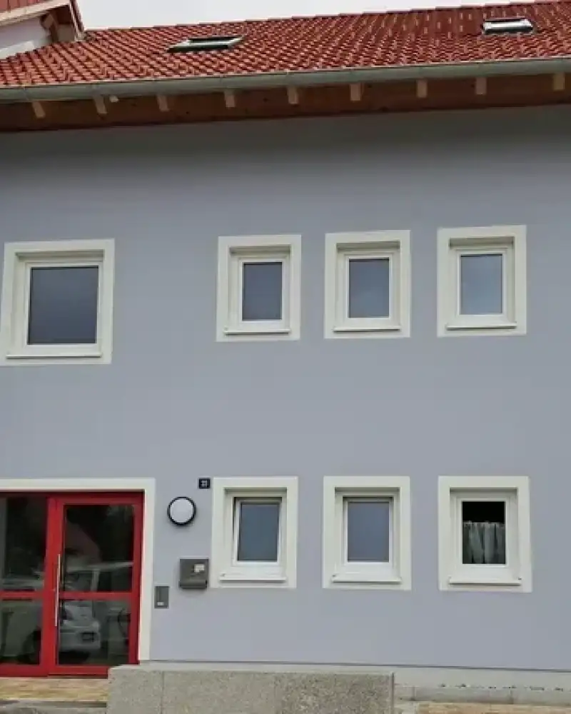 Ein Reihenhaus mit zwei Etagen und einer breiten Eingangstür.