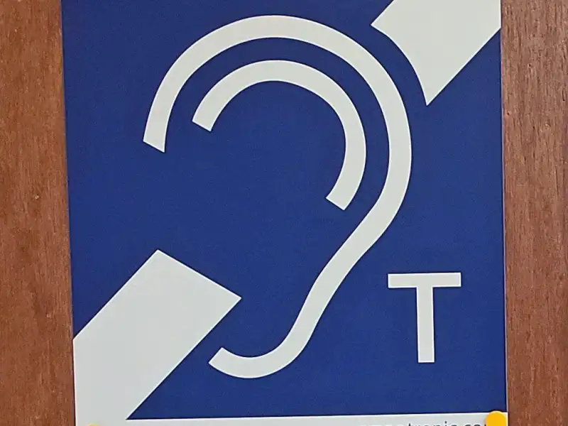 Ein Plakat mit einem stilisierten Ohr und einem T als Symbol für induktive Höranlagen.