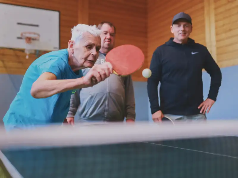 Ältere Dame spielt Tischtennis.