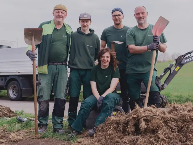 Eine Gruppe von Mitarbeiter*innen eines Gartenbauunternehmens