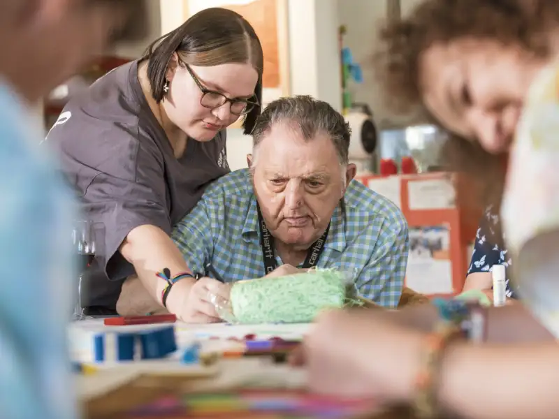 Mehrere Personen beim gemeinsamen Basteln und Gestalten an einem Tisch.