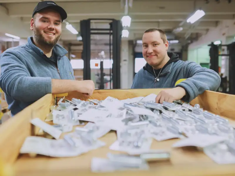 Zwei Männer sortieren Lagerbeschilderungen.