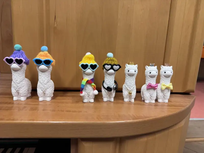 Lustige kleine Lama-Figuren auf einem Regal