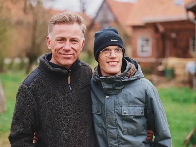 Ein Mann im mittleren Alter und ein junger Mann stehen nebeneinander