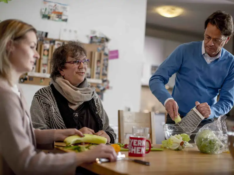 Drei Personen an einem Esstisch