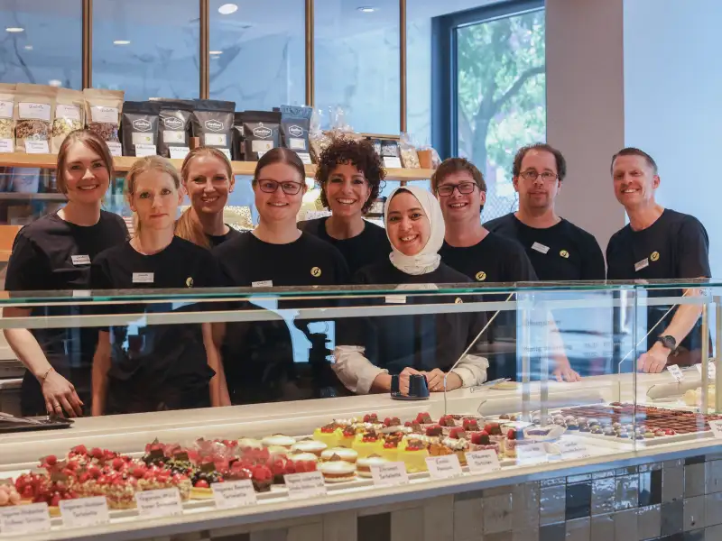 Gruppe von Menschen hinter dem Thresen einer Patisserie