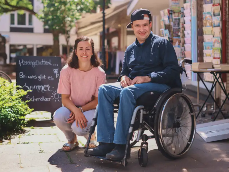 Ein Mann im Rollstuhl und eine junge Frau