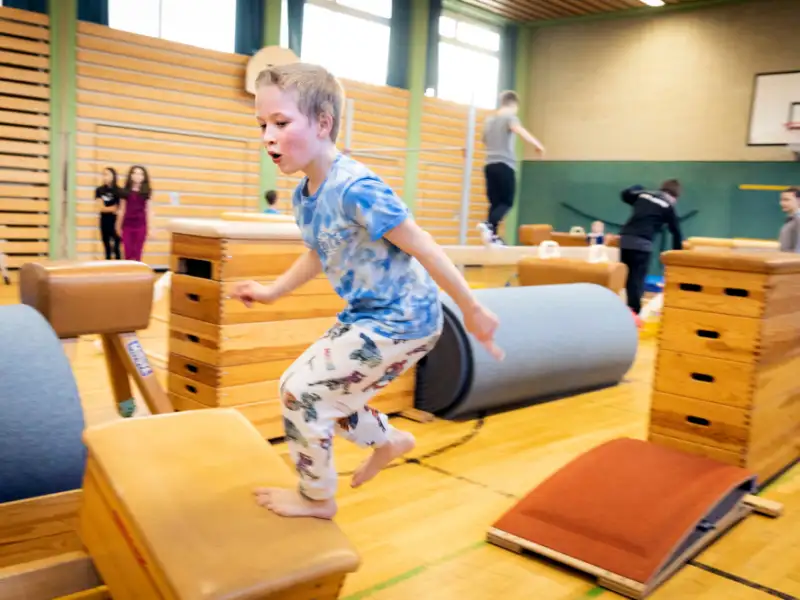 Ein Junge beim Turnen in einer Halle