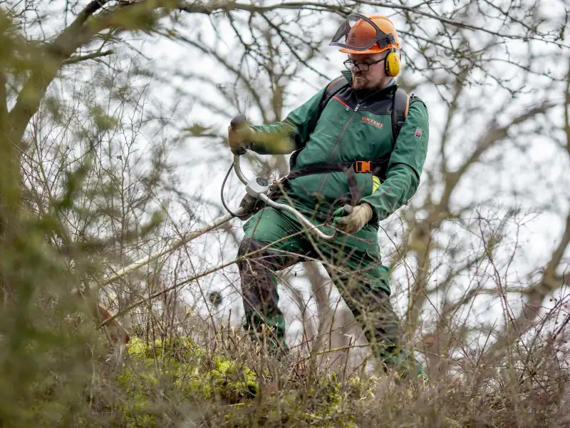 Ein Mitarbeiter einer Gartenlandschaftsfirma arbeitet im Grünen