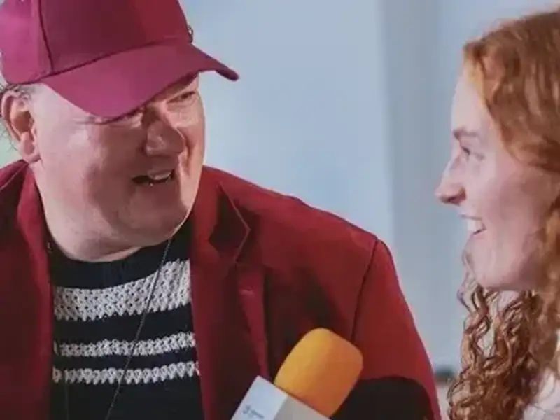 Ein Mann mit Mikrofon im Gesräch mit einer jungen Frau