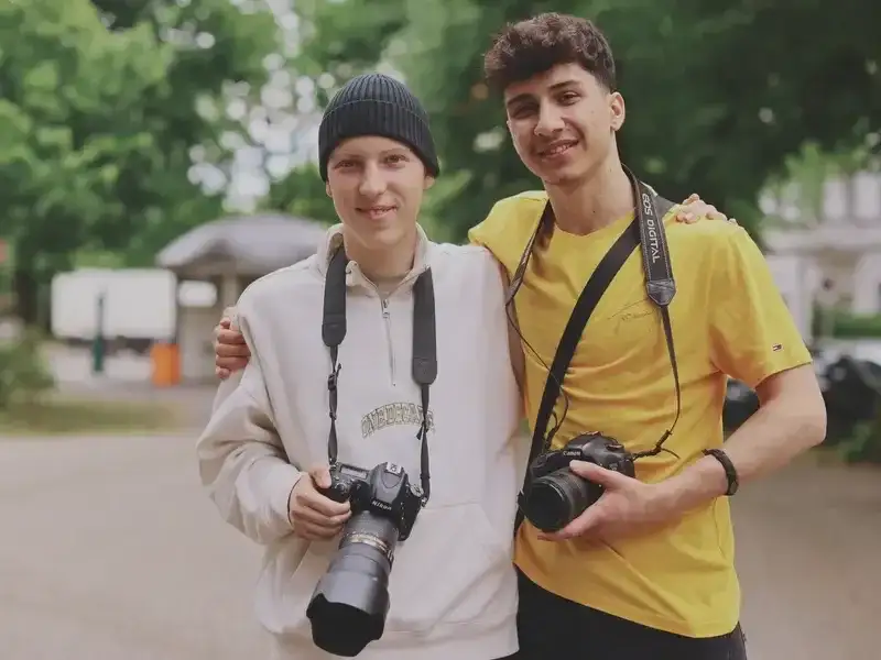 Zwei junge Männer mit Fotokameras