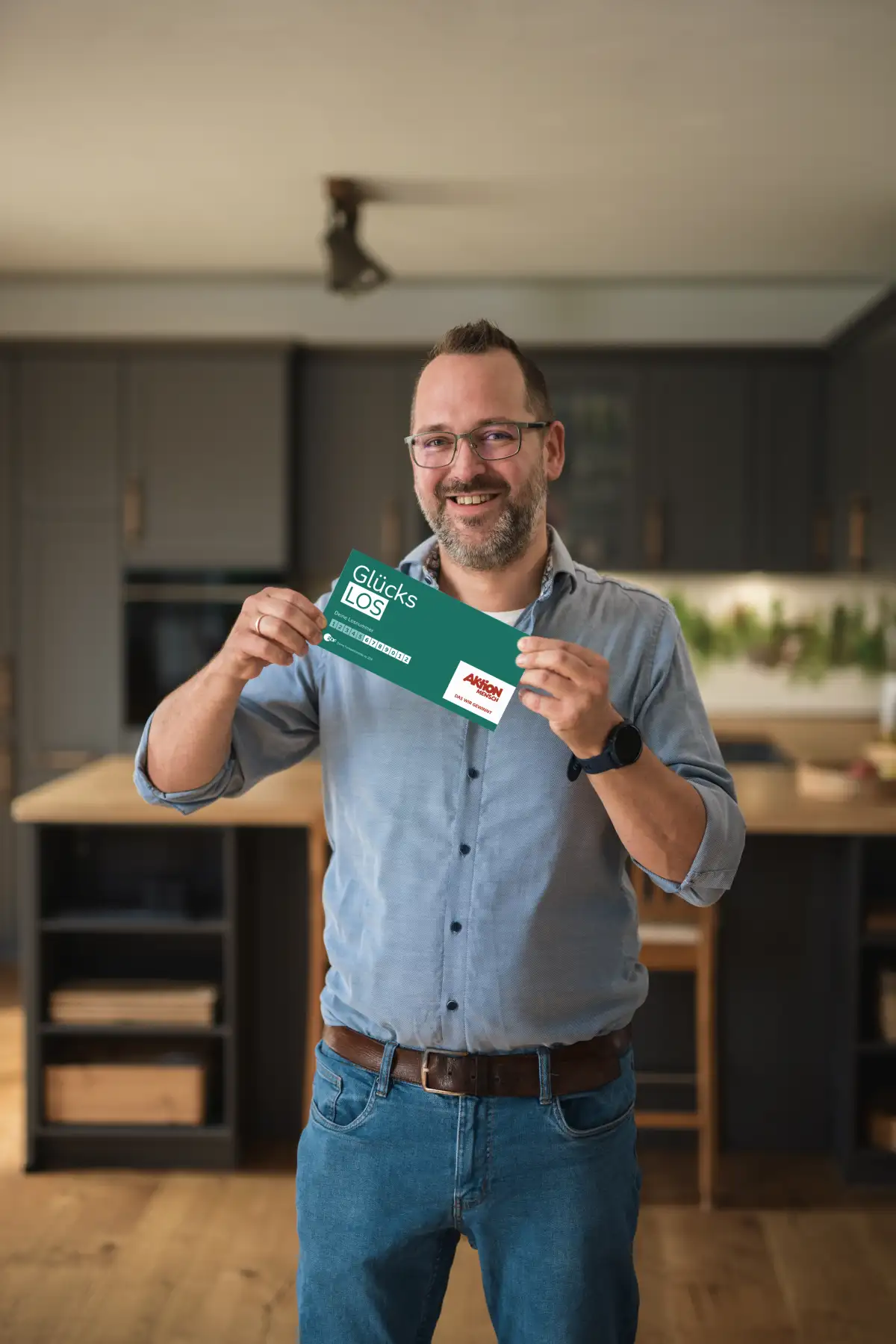 Mann hält freudestrahlend sein Glückslos in der Hand und freut sich über seinen Gewinn.