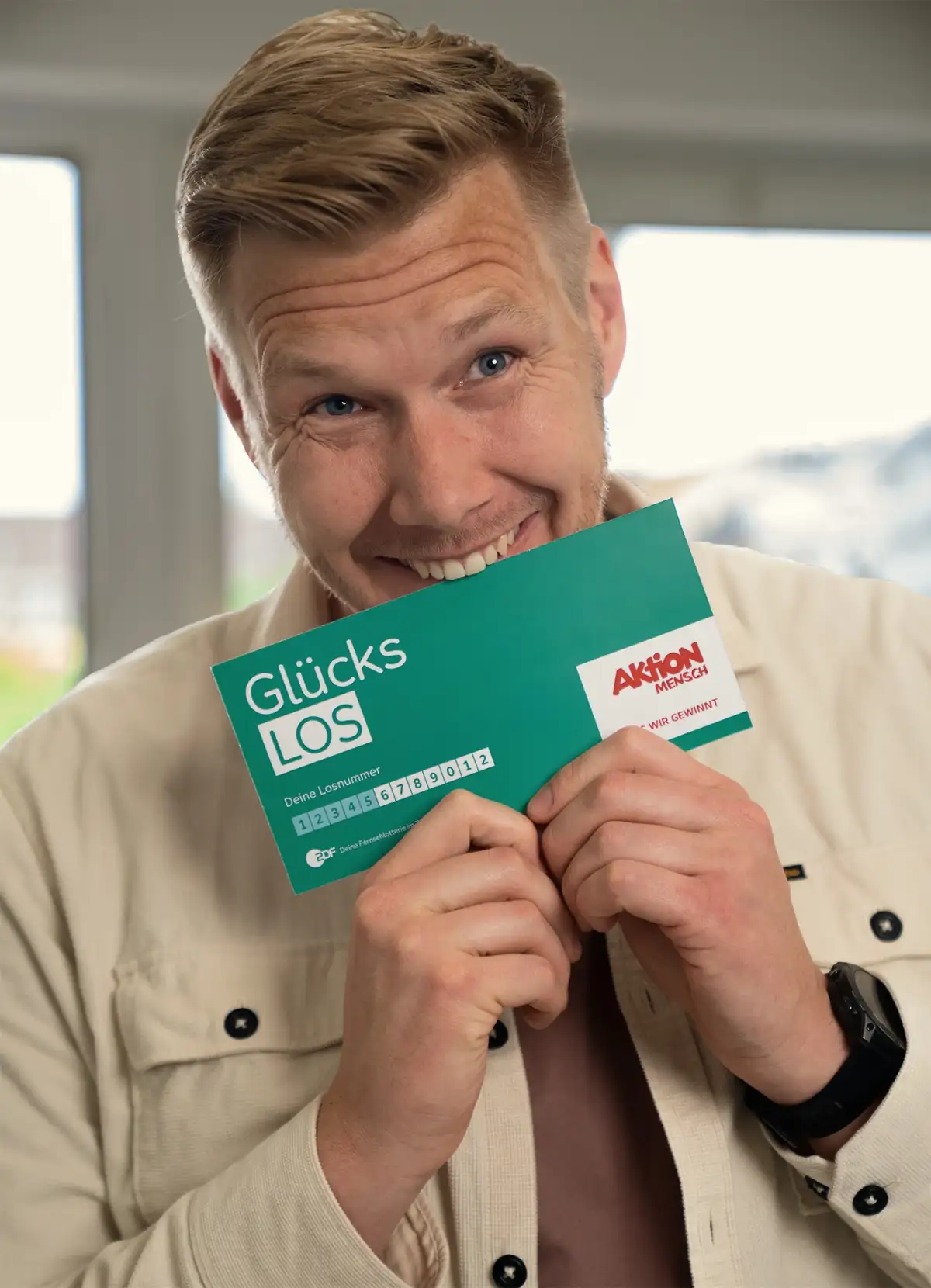 Mann beißt vor Freude über seinen Gewinn in sein Glückslos.