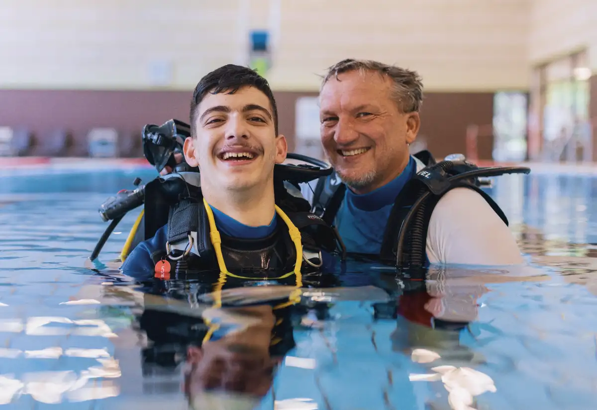 Ein Gewinner besucht ein von der Mensch gefördertes Projekt und erfährt wie sein Los beiträgt das Erlernen des Tauchens für Menschen mit Behinderung zu ermöglichen.