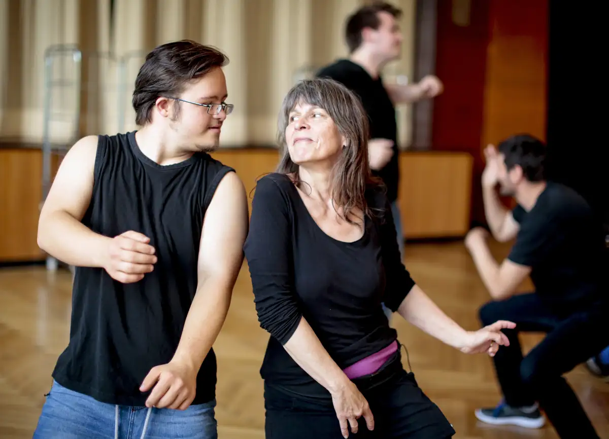 Ein Mann mit Behinderung und eine Frau tanzen mit Freude beim inklusiven Tanzworkshop in Mölln.