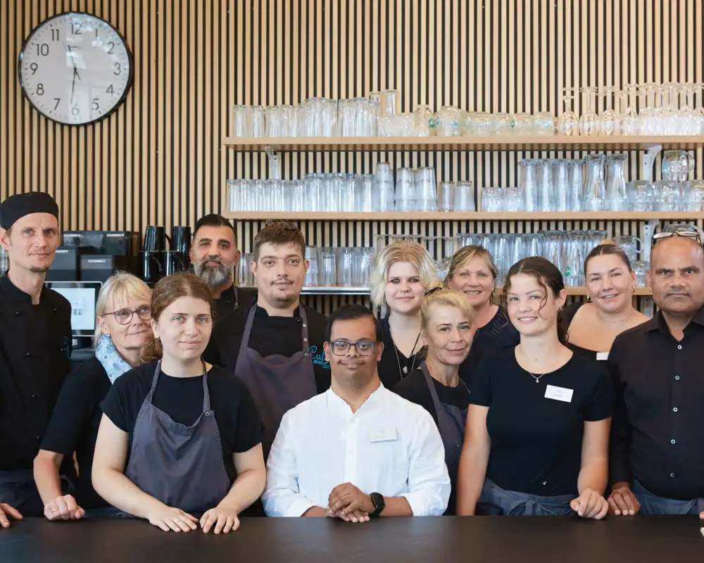 Eine Gruppe von unterschiedlichen Menschen, die in einem Café arbeiten.