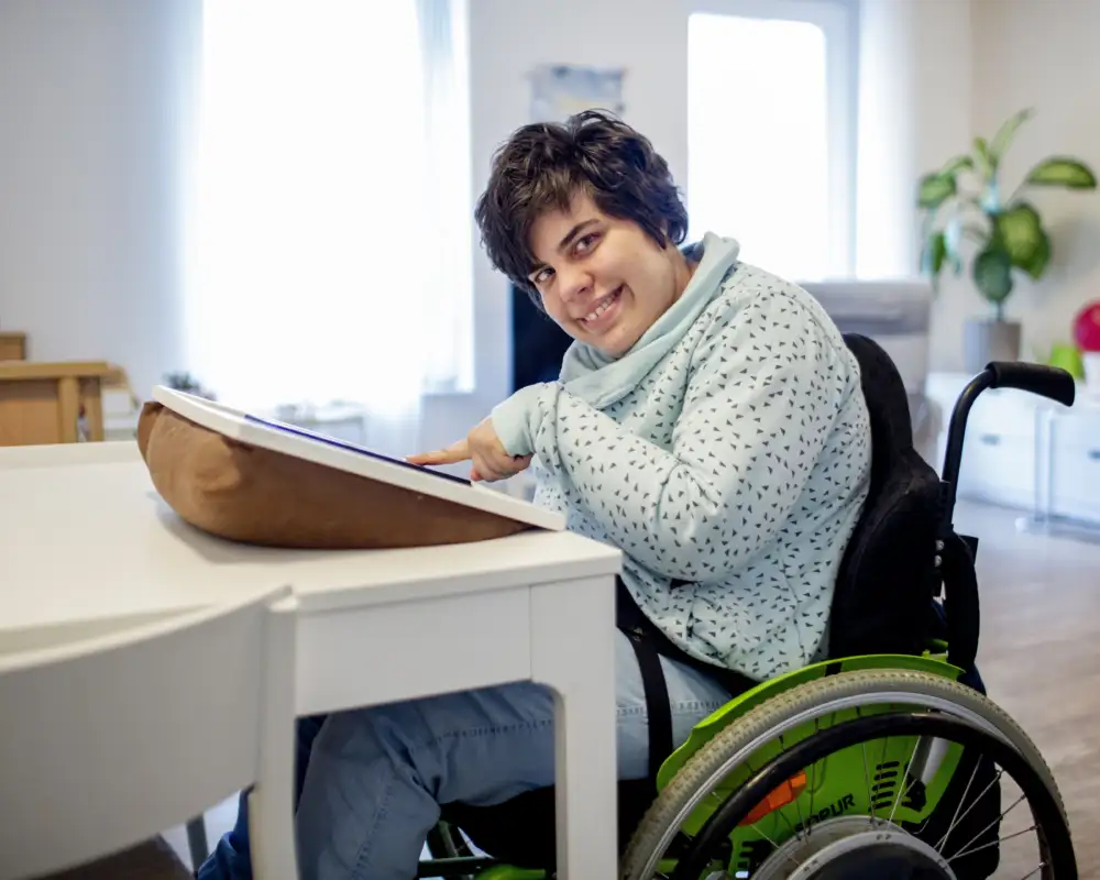 Eine Frau im Rollstuhl bedient zu Hause ein Tablet