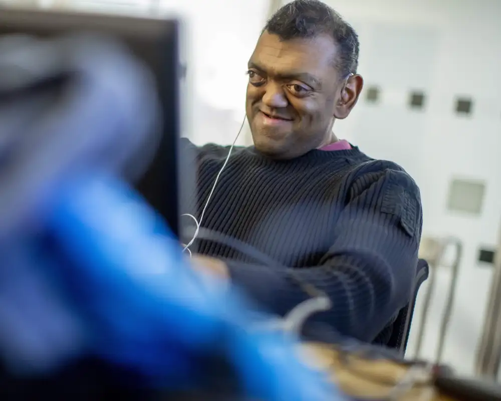 Ein blinder Mann arbeitet am Laptop