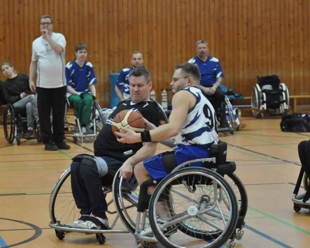 Zwei Männer spielen Rollstuhlbasketball.