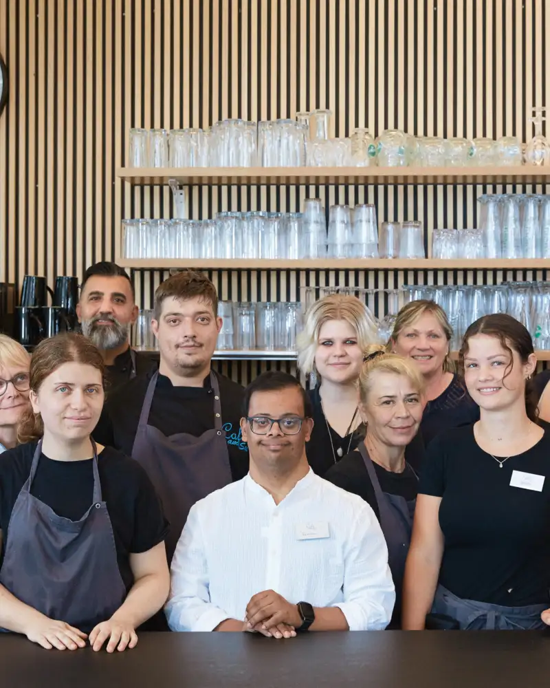 Eine Gruppe von unterschiedlichen Menschen, die in einem Café arbeiten.