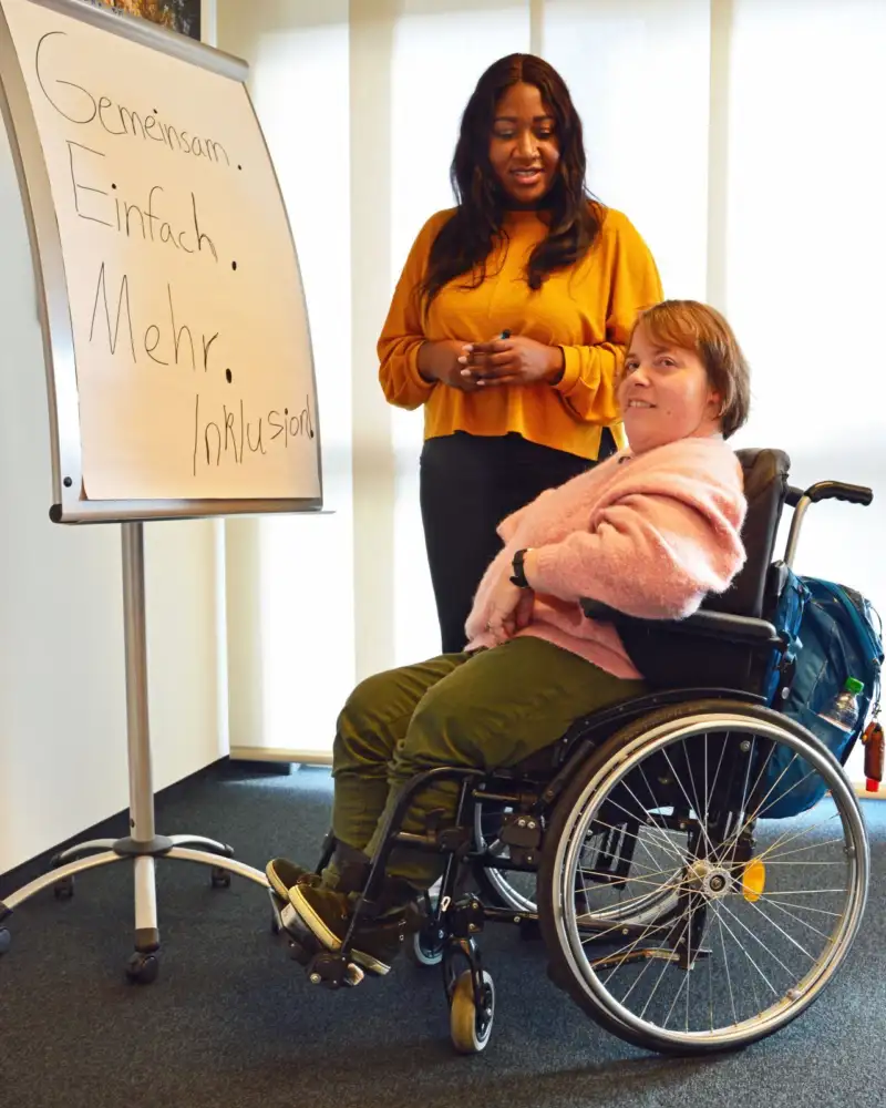 Helle Deertz mit ihrer Assistentin Sylvie Toumonzoni vor einem Flipchart.