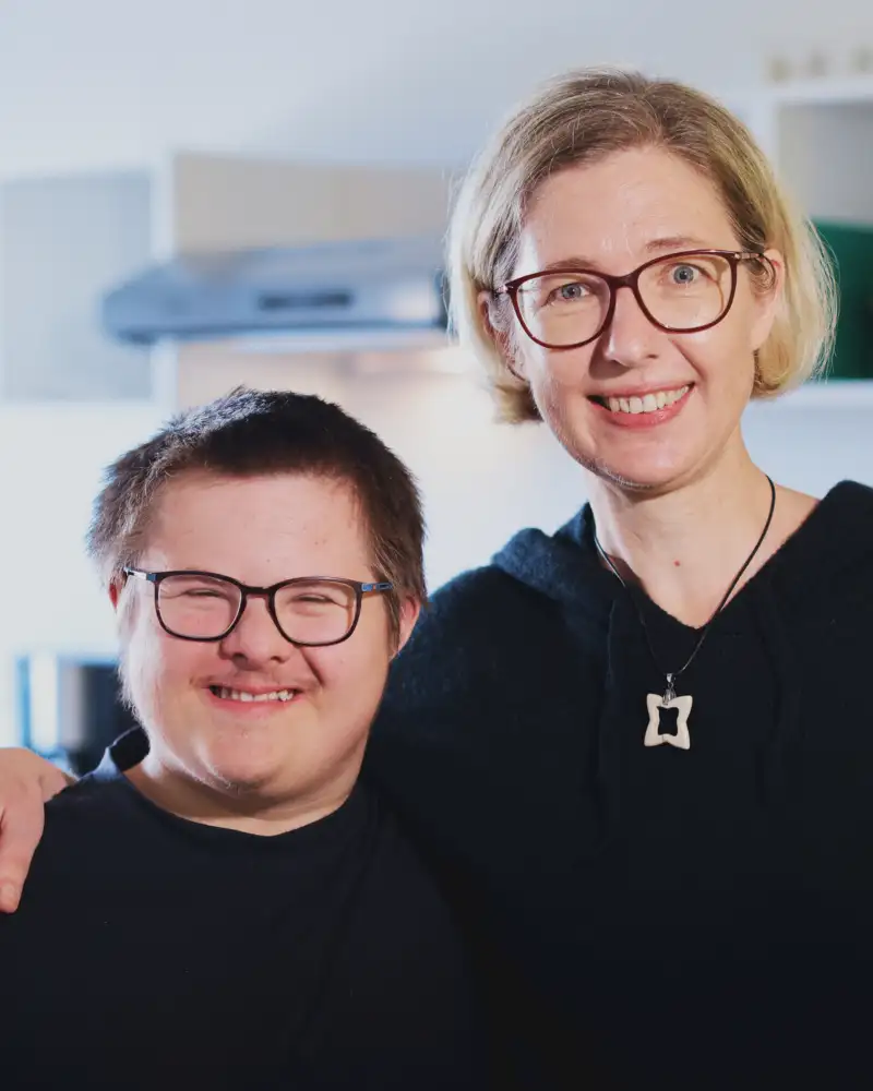 Ein junger Mann und eine junge Frau lächeln in die Kamera.