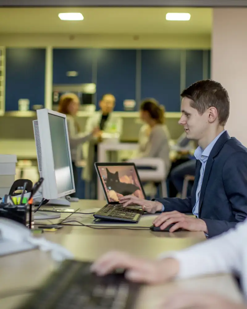 Ein junger Mann und eine junge Frau schauen auf den Computer-Bildschirm.